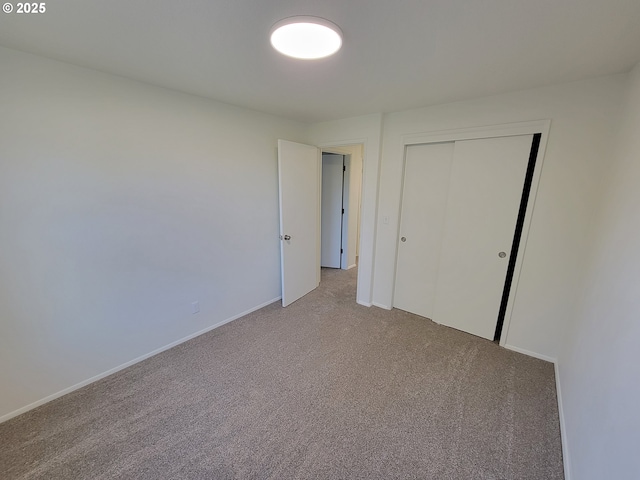 unfurnished bedroom featuring light colored carpet and a closet