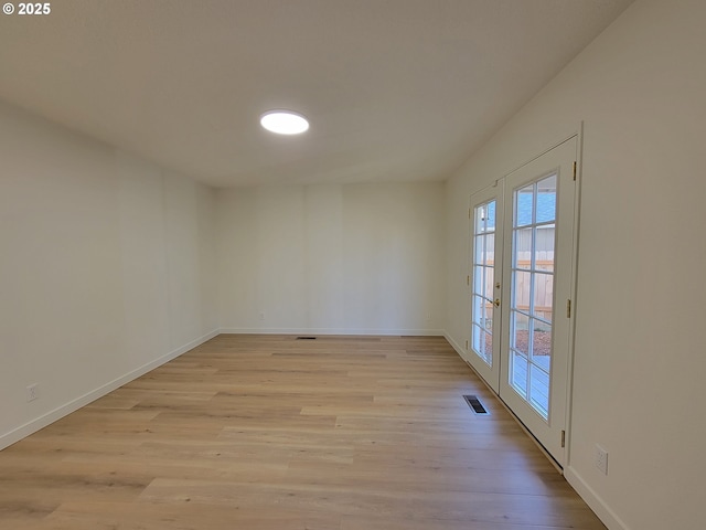 unfurnished room featuring french doors and light hardwood / wood-style flooring