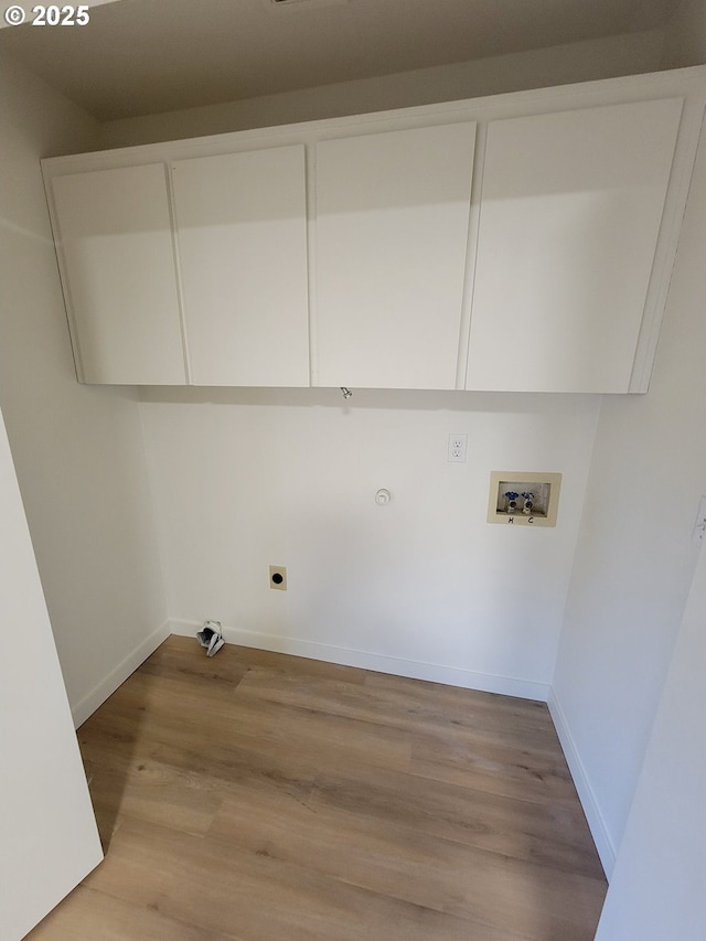 clothes washing area with gas dryer hookup, cabinets, light wood-type flooring, electric dryer hookup, and washer hookup