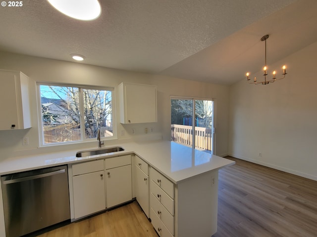 kitchen with sink, decorative light fixtures, dishwasher, kitchen peninsula, and white cabinets