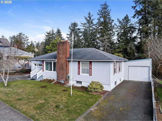 view of front of property with aphalt driveway, a chimney, a front yard, a garage, and an outdoor structure