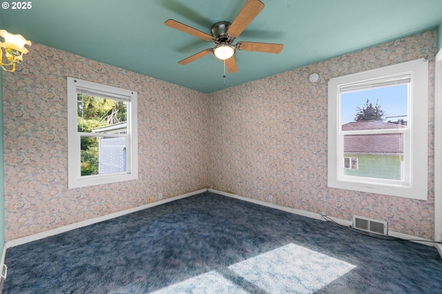 spare room featuring carpet floors, wallpapered walls, baseboards, and visible vents