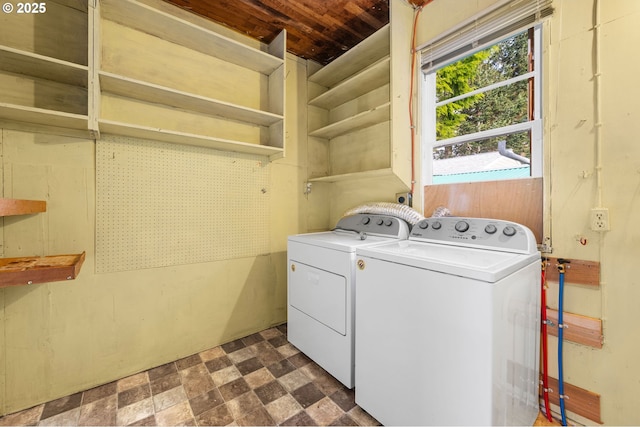 clothes washing area featuring laundry area, dark floors, and separate washer and dryer