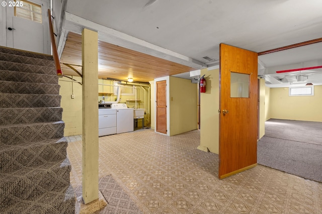 basement featuring light floors, visible vents, stairway, and independent washer and dryer