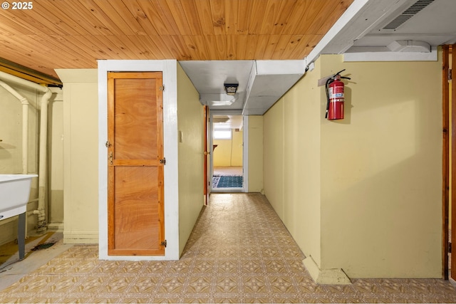 corridor featuring wooden ceiling, visible vents, and tile patterned floors