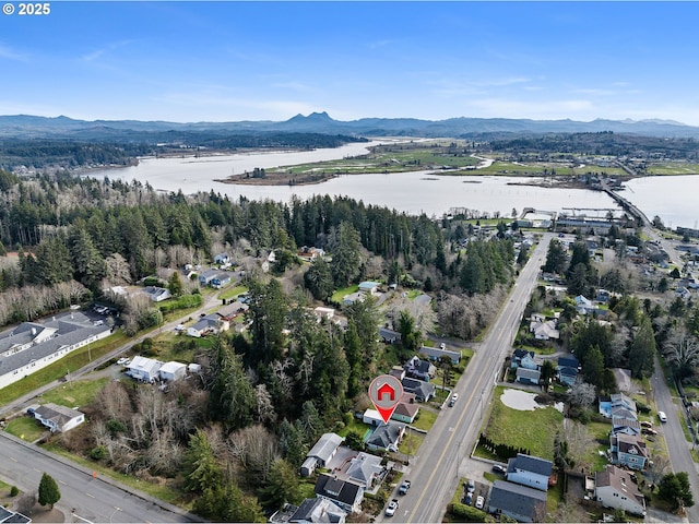 birds eye view of property with a water and mountain view