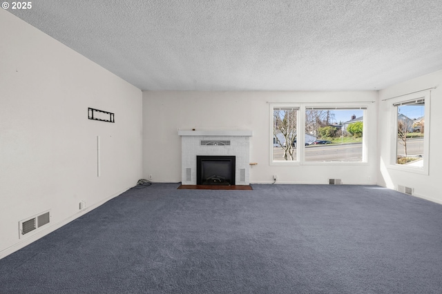 unfurnished living room with plenty of natural light, visible vents, and a brick fireplace