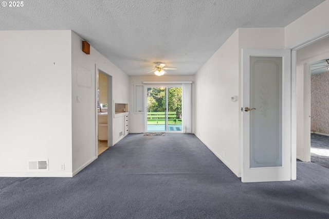 interior space featuring ceiling fan, visible vents, and a textured ceiling