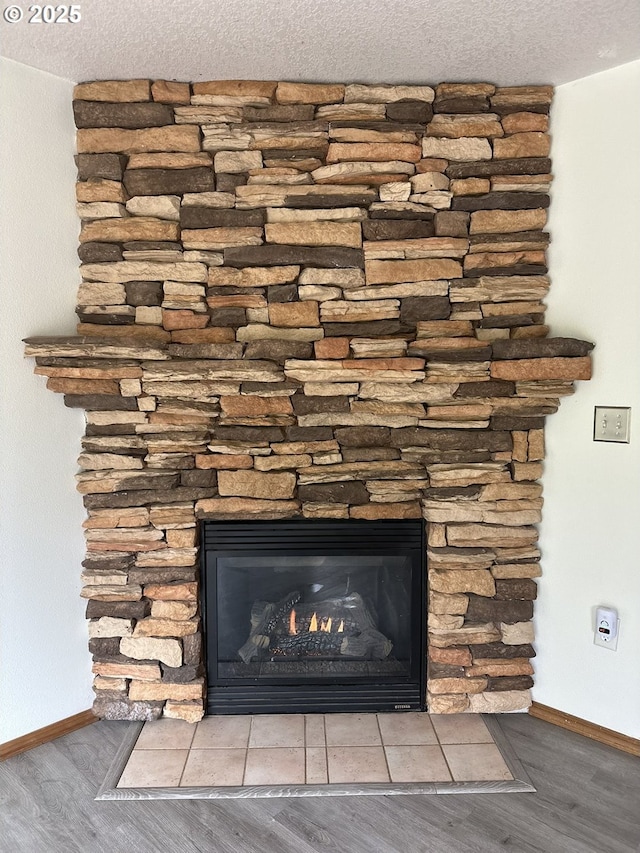 14237 SE Lee Ave, Milwaukie, OR 97267 - detailed view of baseboards, wood finished floors, a fireplace, and a textured ceiling