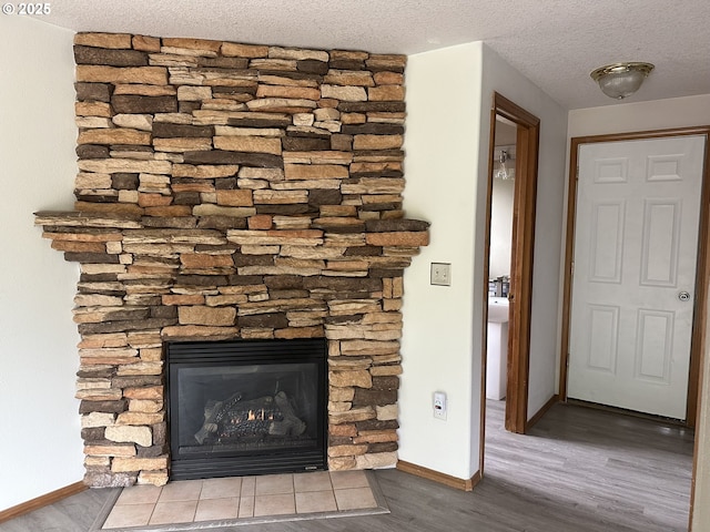 14237 SE Lee Ave, Milwaukie, OR 97267 - detailed view of wood finished floors, baseboards, a fireplace, and a textured ceiling