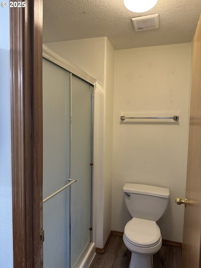 14237 SE Lee Ave, Milwaukie, OR 97267 - bathroom featuring wood finished floors, a stall shower, baseboards, toilet, and a textured ceiling