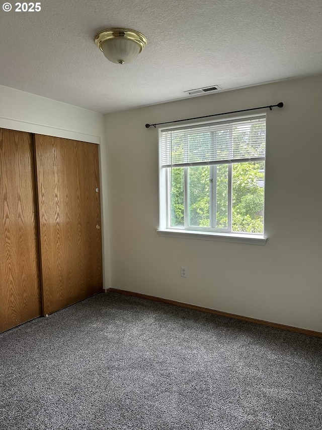 14237 SE Lee Ave, Milwaukie, OR 97267 - unfurnished bedroom with a closet, carpet flooring, baseboards, and a textured ceiling