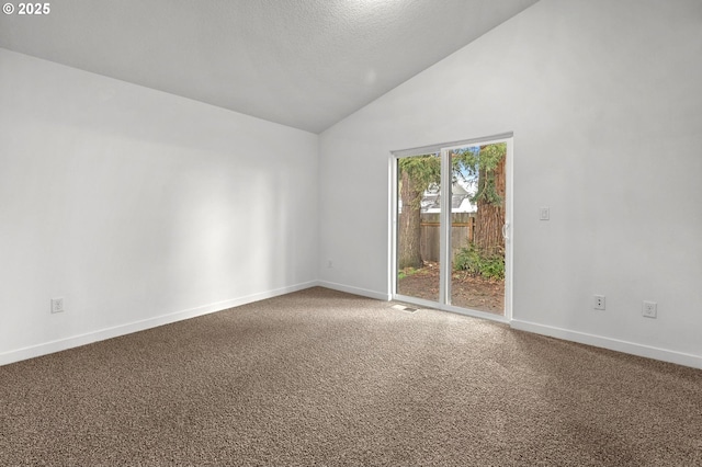 spare room featuring carpet, lofted ceiling, and a textured ceiling