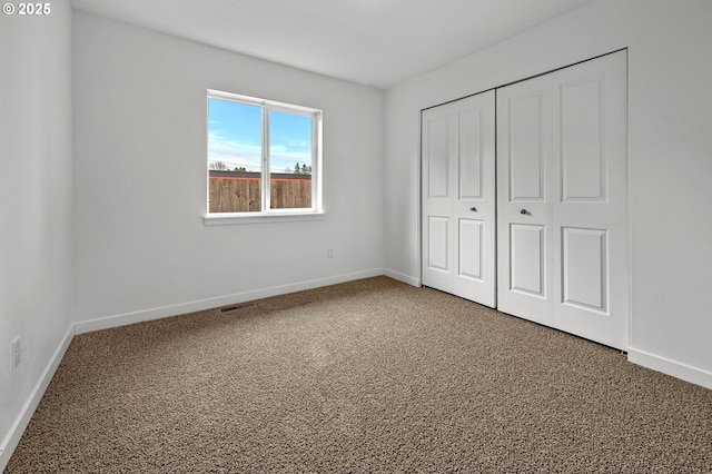 unfurnished bedroom featuring carpet floors and a closet