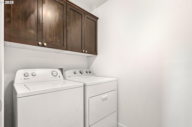 laundry area featuring washing machine and dryer and cabinets