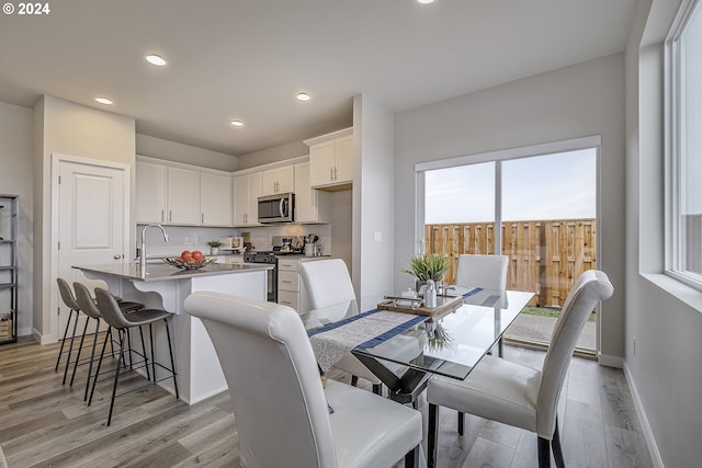 dining room featuring recessed lighting, baseboards, and light wood finished floors