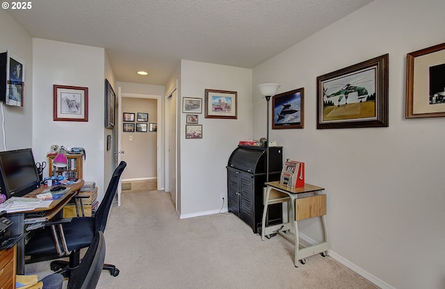 office featuring light carpet and a textured ceiling