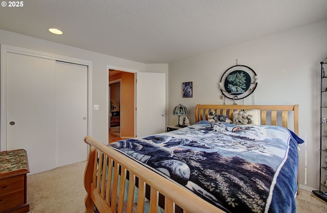 carpeted bedroom featuring a textured ceiling and a closet