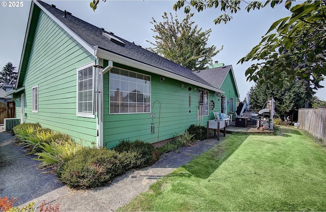 view of side of property featuring a patio area, central air condition unit, and a lawn