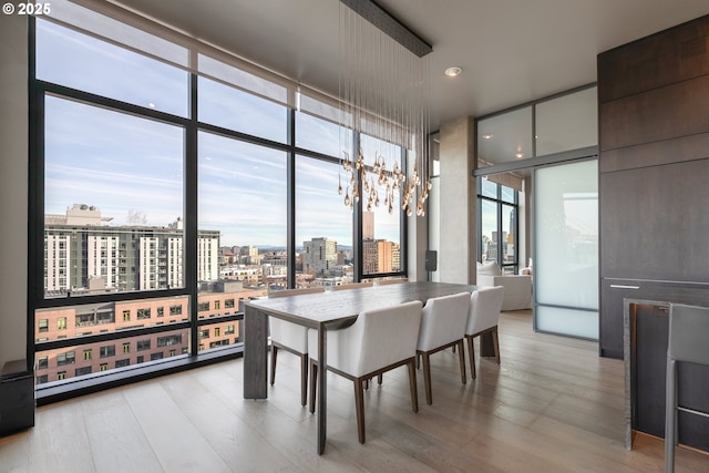 dining room featuring expansive windows and light hardwood / wood-style floors