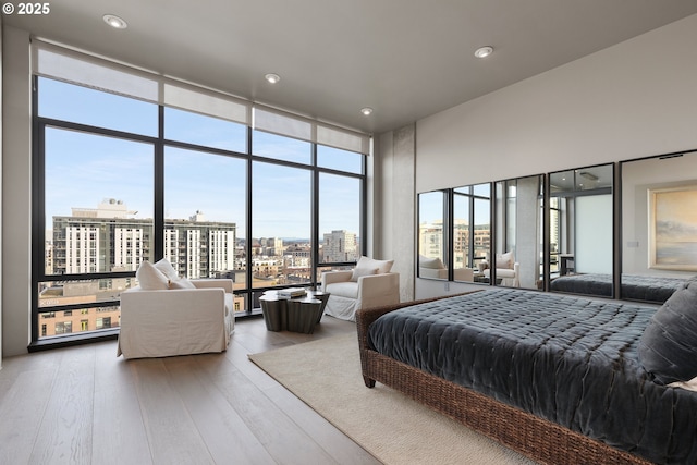 bedroom with hardwood / wood-style flooring and a wall of windows