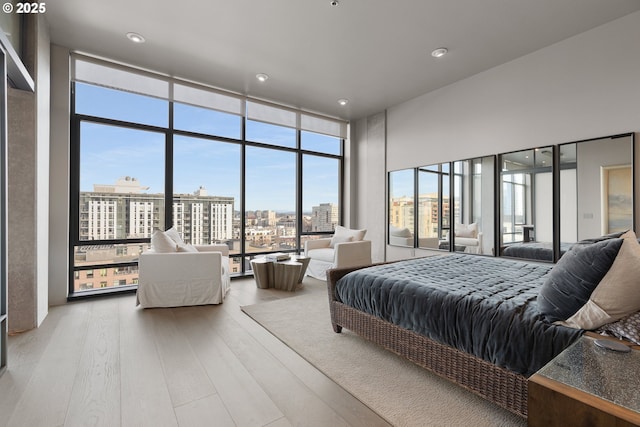 bedroom with hardwood / wood-style flooring and a wall of windows