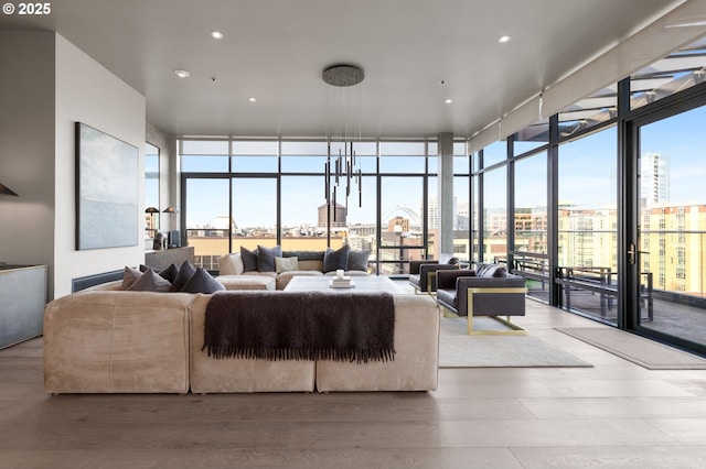 living room with a wall of windows, wood-type flooring, and plenty of natural light