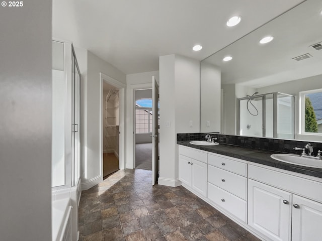 clothes washing area with washing machine and dryer, laundry area, visible vents, and baseboards