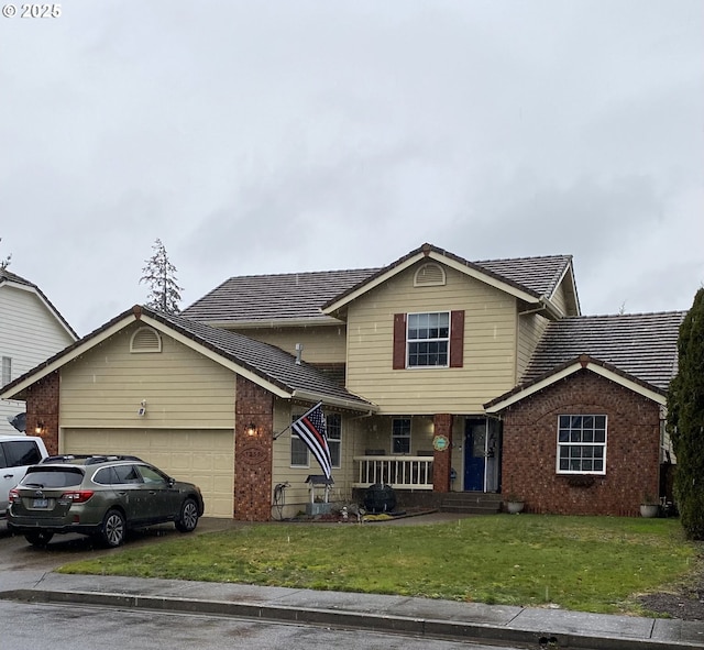 traditional-style house with a garage, brick siding, and a front yard