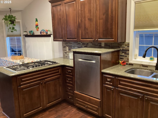 kitchen with appliances with stainless steel finishes, sink, tasteful backsplash, and dark hardwood / wood-style flooring