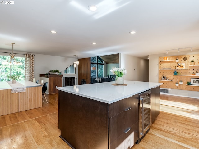 2490 SW Scenic Dr, Portland, OR 97225 - kitchen featuring wine cooler, modern cabinets, light wood-style flooring, a kitchen island, and recessed lighting