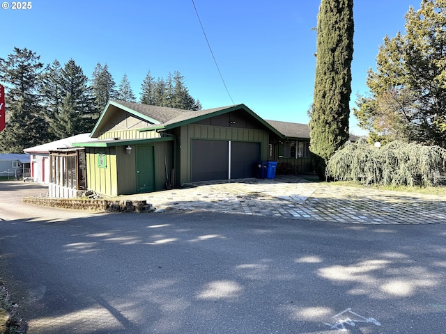 exterior space featuring board and batten siding, driveway, and a garage