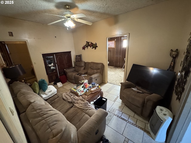 living area with a textured ceiling, light tile patterned flooring, and a ceiling fan