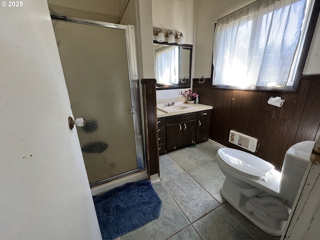 bathroom with a wainscoted wall, toilet, wood walls, a shower stall, and vanity