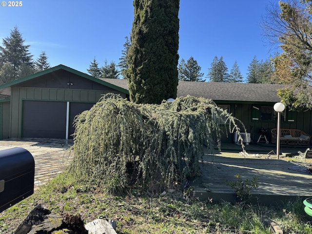 view of side of property with board and batten siding and roof with shingles