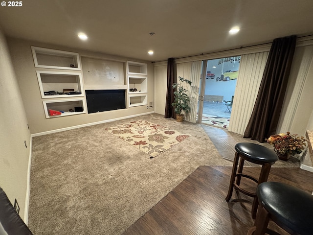 living area with recessed lighting, a fireplace, baseboards, and wood finished floors