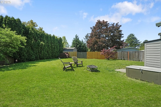 view of yard with a fenced backyard and a fire pit