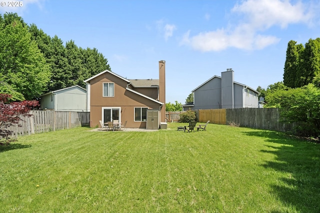 back of house with a lawn, a fenced backyard, stucco siding, and a patio