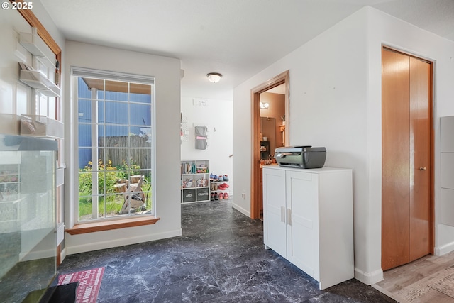 corridor featuring baseboards and a wealth of natural light