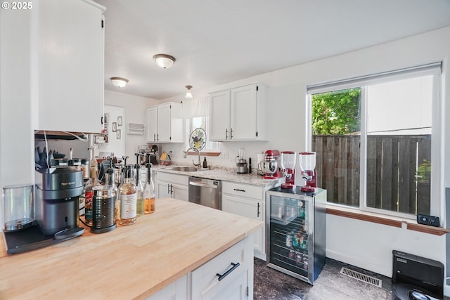 kitchen featuring visible vents, dishwasher, a sink, wine cooler, and white cabinetry