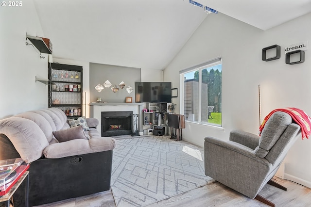 living room with wood finished floors, lofted ceiling, and a fireplace