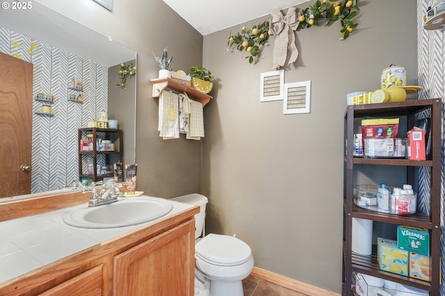half bathroom with toilet, tile patterned flooring, and vanity