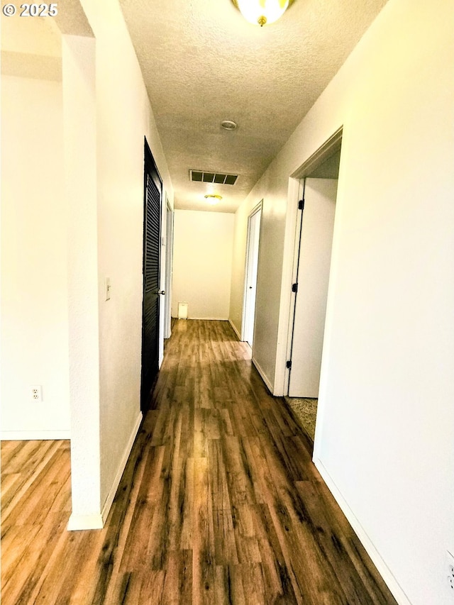 123 1st St, Dillard, OR 97432 - hall with dark wood-type flooring, a textured ceiling, and baseboards