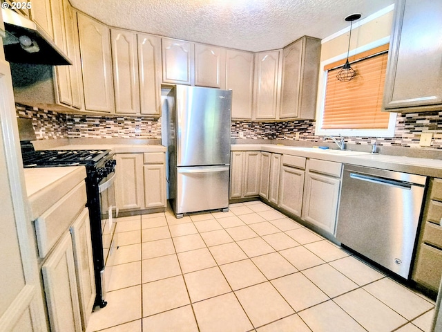 123 1st St, Dillard, OR 97432 - kitchen featuring stainless steel appliances, under cabinet range hood, light countertops, a textured ceiling, and a sink