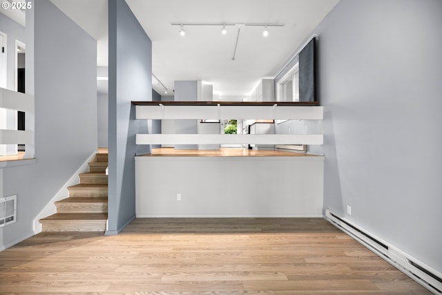 4360 SW Dickinson St Unit 35, Portland, OR 97219 - kitchen featuring a baseboard radiator, wood finished floors, and track lighting