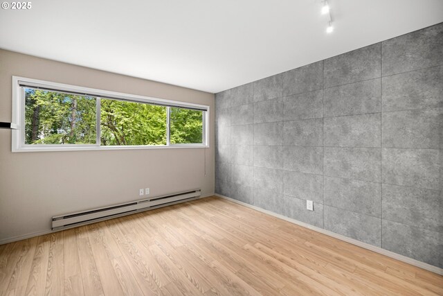 4360 SW Dickinson St Unit 35, Portland, OR 97219 - empty room with baseboard heating, wood finished floors, and baseboards