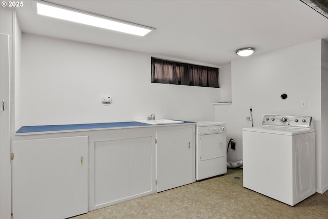 4429 SE Raymond St, Portland, OR 97206 - laundry room featuring separate washer and dryer, light floors, and cabinet space