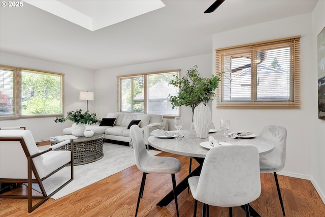 4429 SE Raymond St, Portland, OR 97206 - dining area featuring plenty of natural light, a ceiling fan, wood finished floors, and a skylight