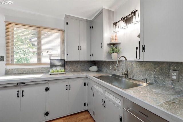 4429 SE Raymond St, Portland, OR 97206 - kitchen featuring stainless steel dishwasher, decorative backsplash, light countertops, and light wood-style flooring