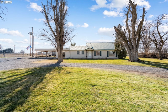 view of front of property featuring metal roof and a front yard